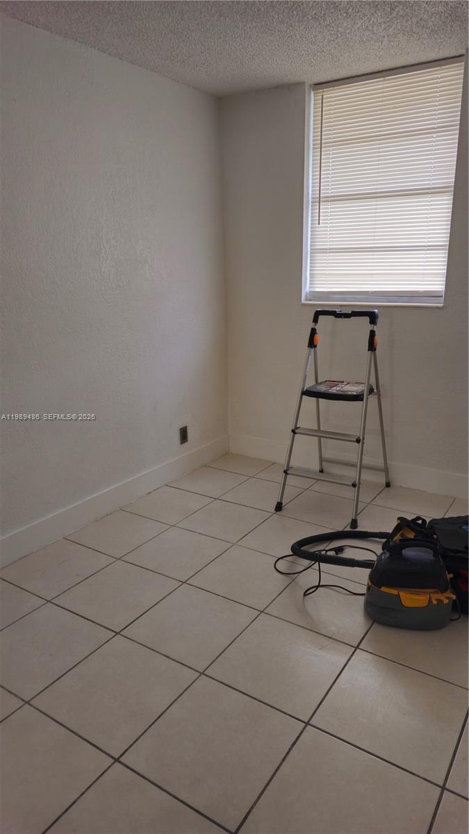 A small room features white walls, tiled flooring, a window with blinds, and a stepladder — 4550 NW 9th St # 505E, Miami FL 33126, MIAMI, FL