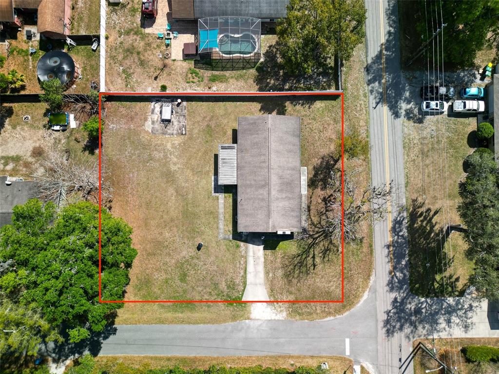 An aerial view shows a house on a rectangular lot outlined in red — 975 N BOSTON AVENUE, DELAND, FL