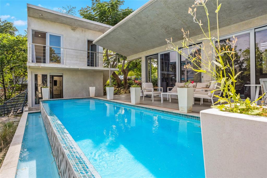 A modern two-story house with a rectangular swimming pool and a covered outdoor patio area — PR 413 SOLAR C BO. PUNTAS, RINCON, PR