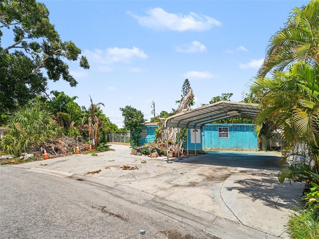 A teal mobile home with a metal carport sits on a concrete driveway — 2839 19TH STREET W, BRADENTON, FL