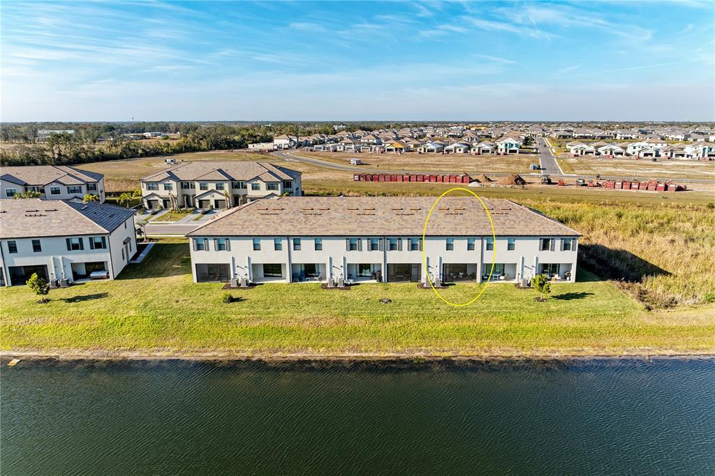 An aerial view shows a multi-unit townhouse building with a screened patio circled in yellow — 14713 LYLA TERRACE, BRADENTON, FL