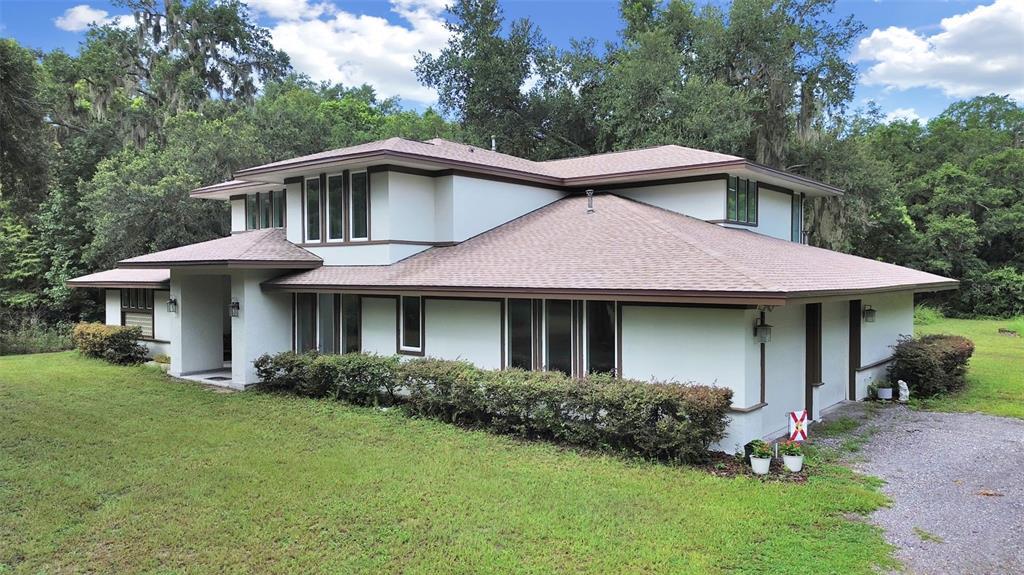 A two-story house with a low-pitched roof, white stucco walls, and dark trim — 1729 FATS LANE, SEFFNER, FL