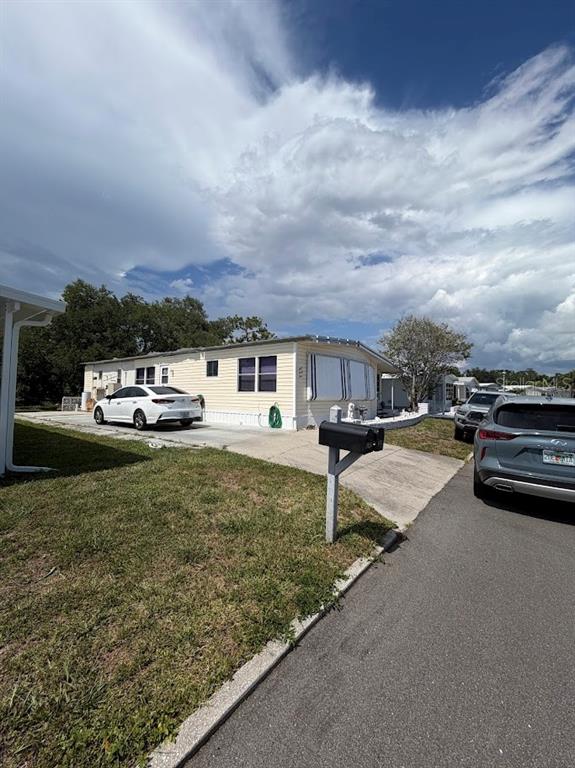 A light-colored mobile home with a concrete driveway and two parked cars — 833 JOLANDA CIRCLE, VENICE, FL