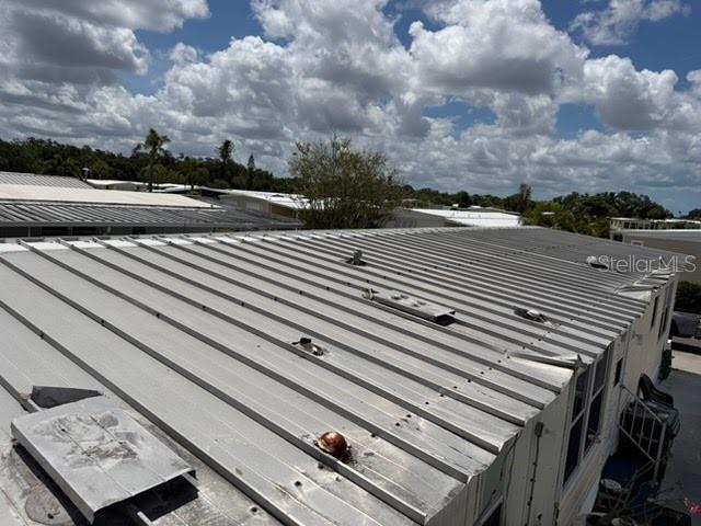 An elevated view of a metal roof on a manufactured home under a cloudy sky — 833 JOLANDA CIRCLE, VENICE, FL