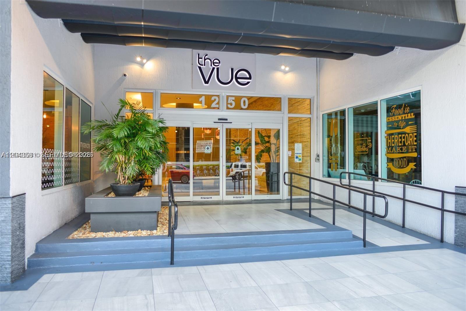 The exterior entrance of a building features glass doors, a potted plant, and metal railings — 1250 S Miami Ave # 1713, Miami FL 33130, MIAMI, FL