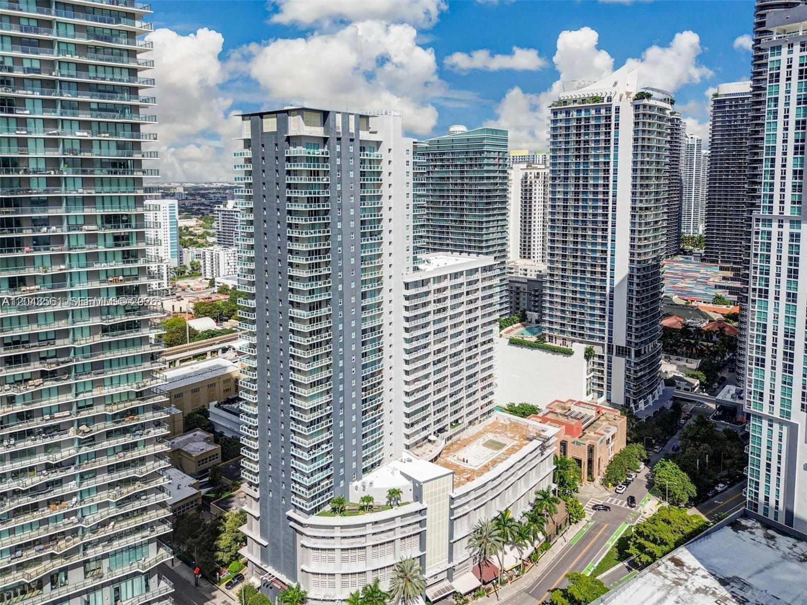 An aerial view shows several tall, modern residential skyscrapers in a dense urban setting — 1250 S Miami Ave # 1713, Miami FL 33130, MIAMI, FL