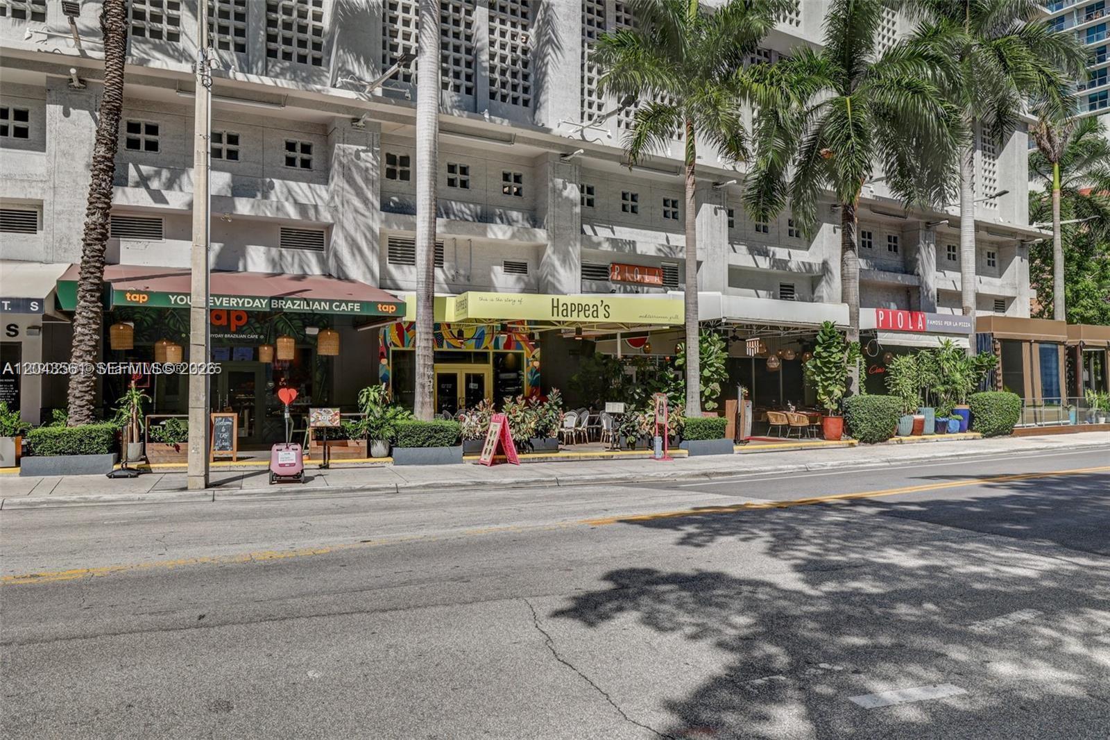 A street-level view of a multi-story building featuring several restaurants with outdoor seating areas — 1250 S Miami Ave # 1713, Miami FL 33130, MIAMI, FL