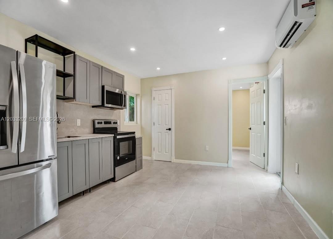 A kitchen features gray cabinets, stainless steel appliances, and light tile flooring — 2442 Garfield St # 4, Hollywood FL 33020, HOLLYWOOD, FL