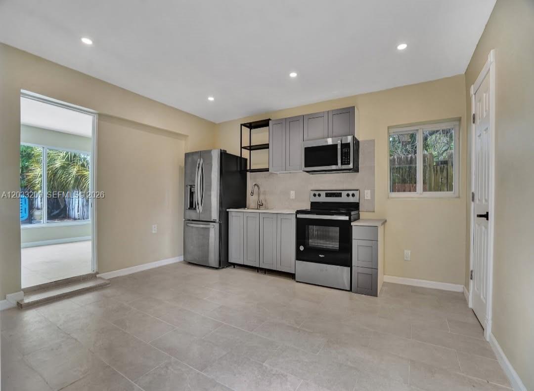 A kitchen features gray cabinets, stainless steel appliances, and light tile flooring — 2442 Garfield St # 4, Hollywood FL 33020, HOLLYWOOD, FL