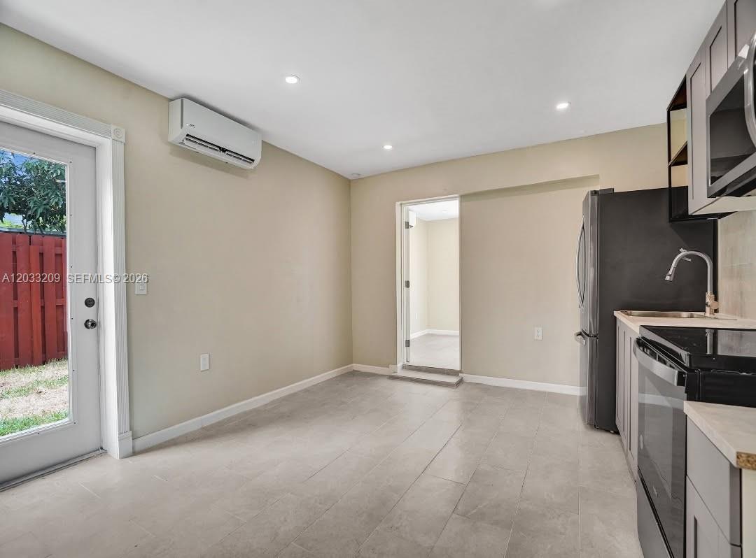 A kitchen with gray cabinets, stainless steel appliances, and a door leading to the outdoors — 2442 Garfield St # 4, Hollywood FL 33020, HOLLYWOOD, FL