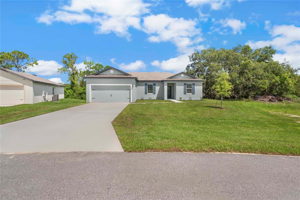 A single-story house with a gray exterior, a two-car garage, and a concrete driveway — 357 BREAM, POINCIANA, FL
