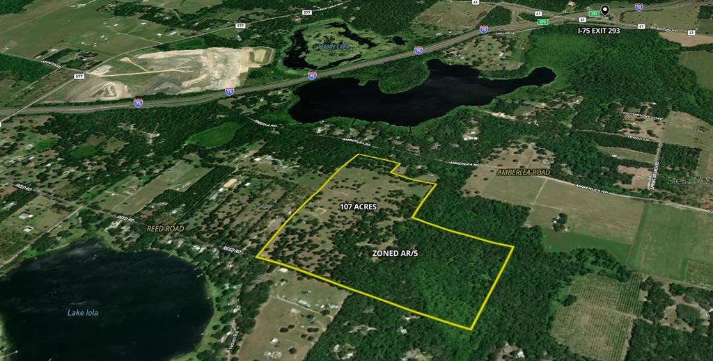 An aerial map shows a 107-acre parcel of land zoned AR/5 near a lake — 31501 REED ROAD, DADE CITY, FL