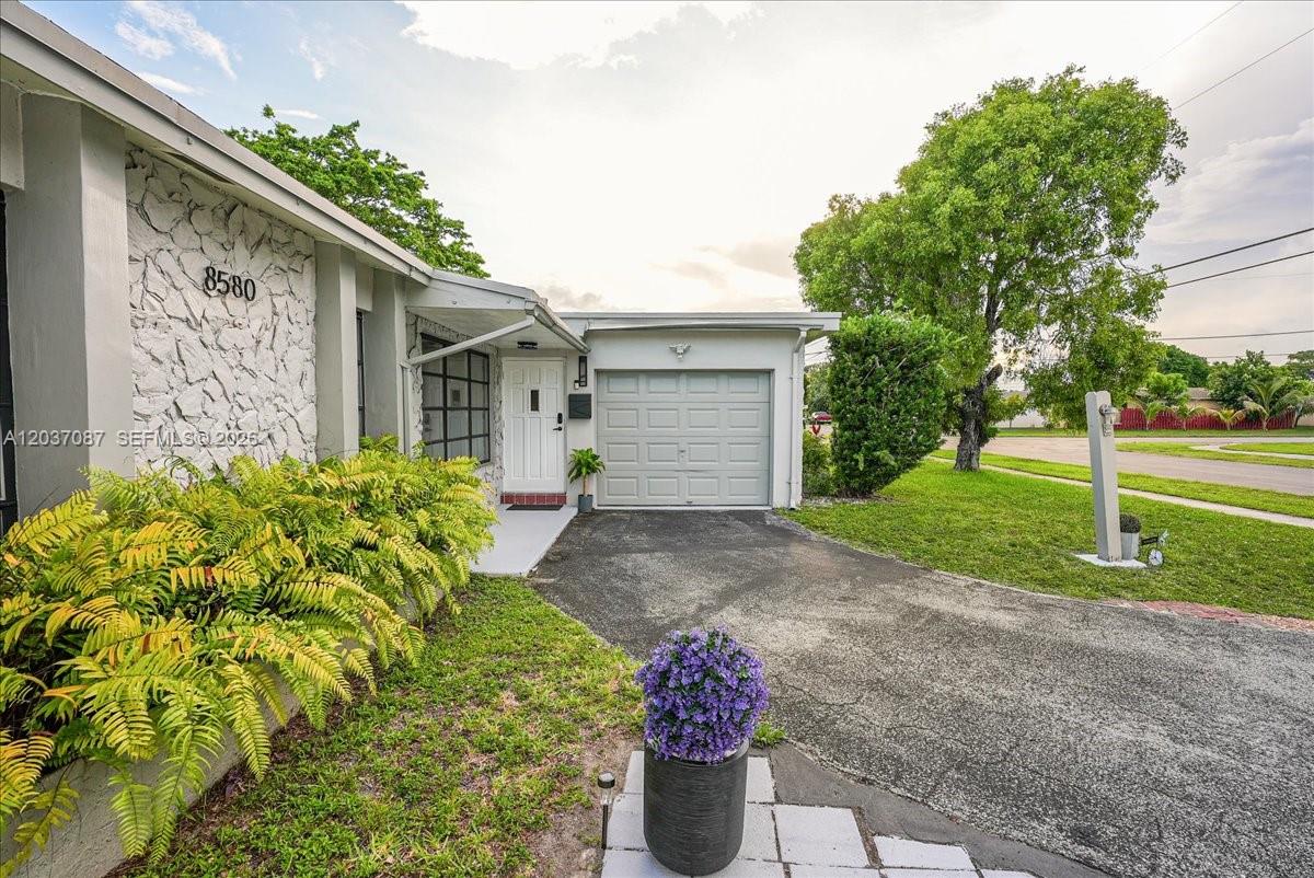 A single-story house features a stone facade, a white front door, and a one-car garage — 8580 NW 20th Ct, Sunrise FL 33322, SUNRISE, FL