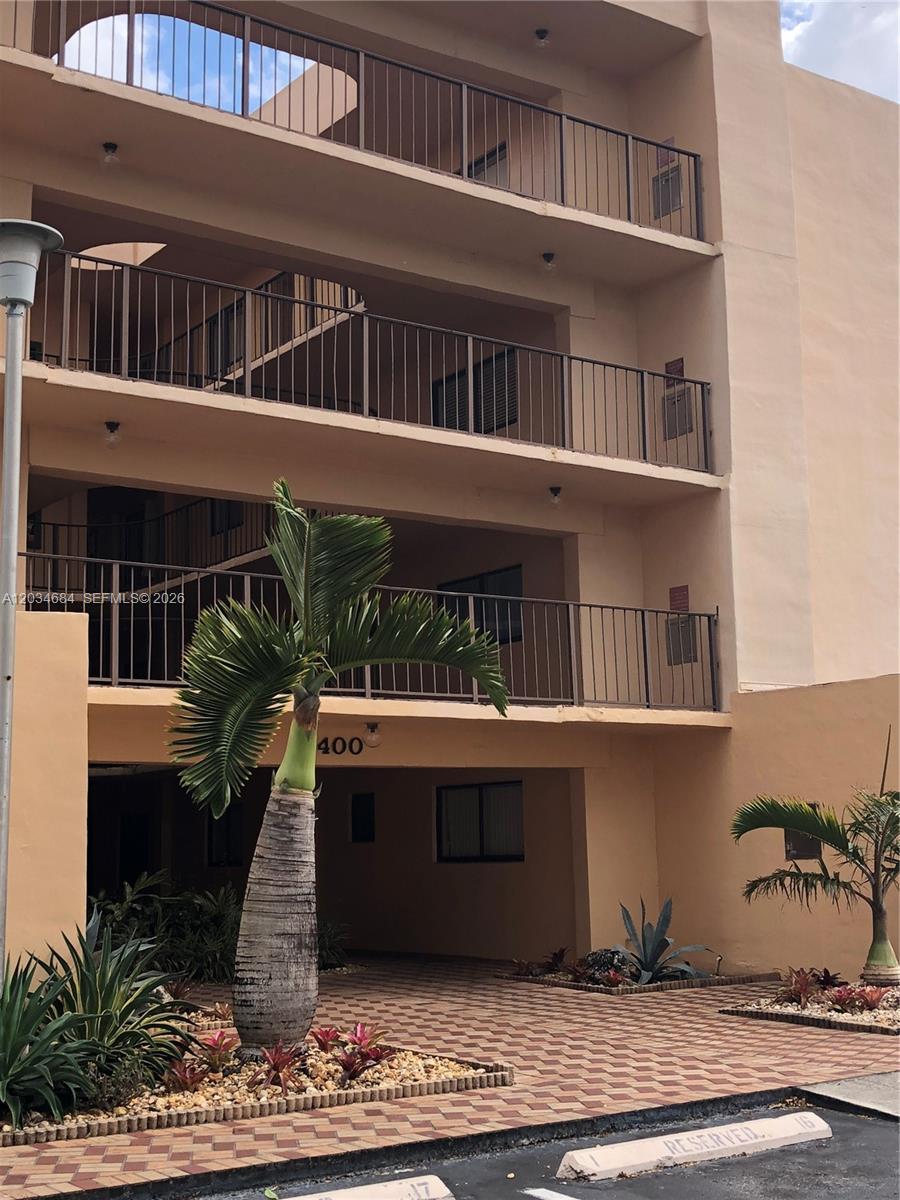 A three-story apartment building exterior features balconies, a palm tree, and a paved driveway — 8400 SW 133rd Ave Rd # 324, Miami FL 33183, MIAMI, FL