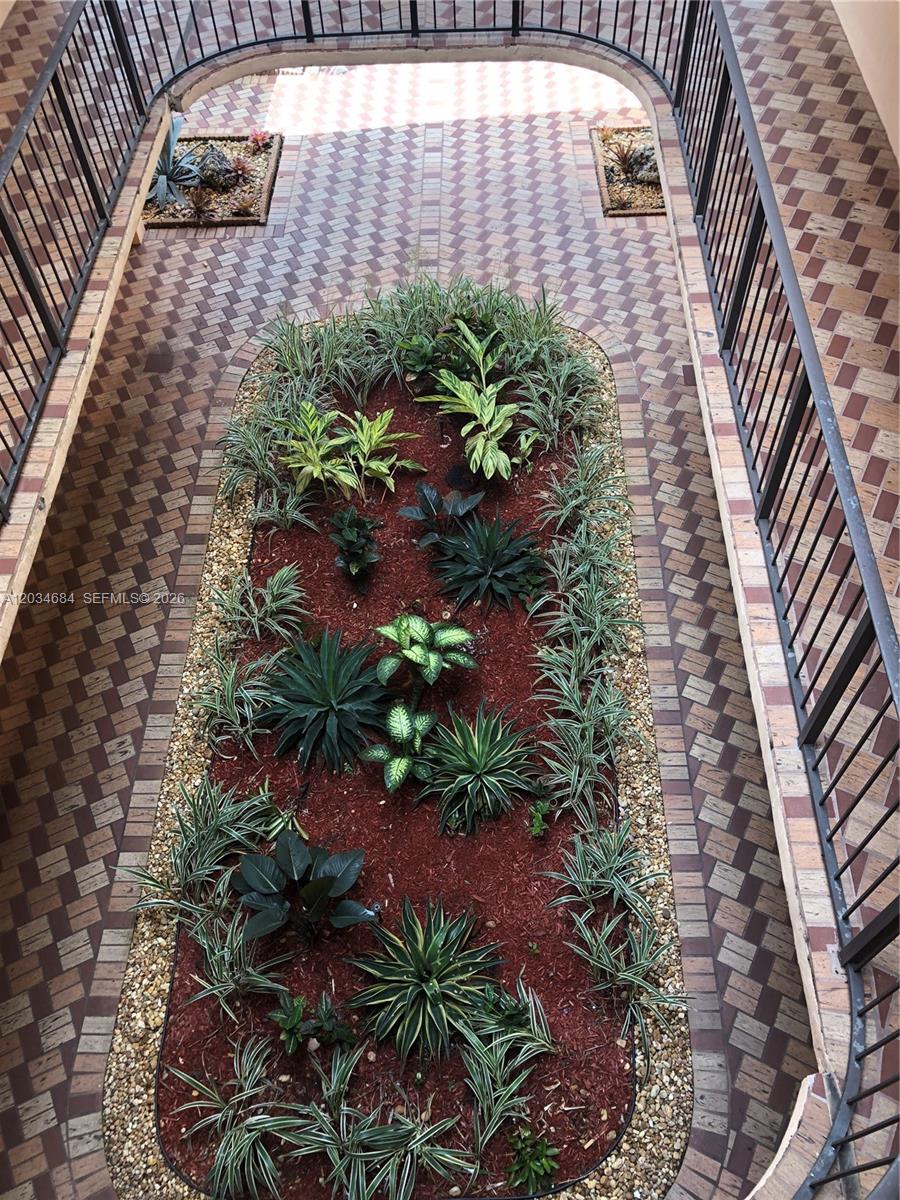 An elevated view of a landscaped courtyard with a central garden bed and brick pavers — 8400 SW 133rd Ave Rd # 324, Miami FL 33183, MIAMI, FL