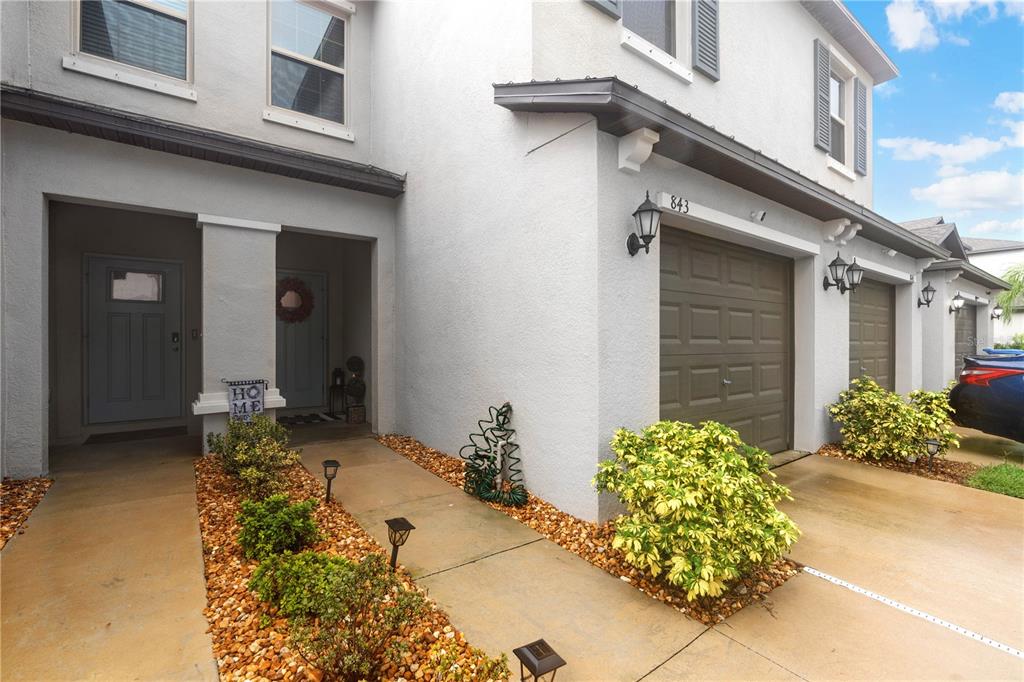This exterior view shows a two-story townhouse with a garage and a front walkway — 843 ROYAL EMPRESS DRIVE, RUSKIN, FL