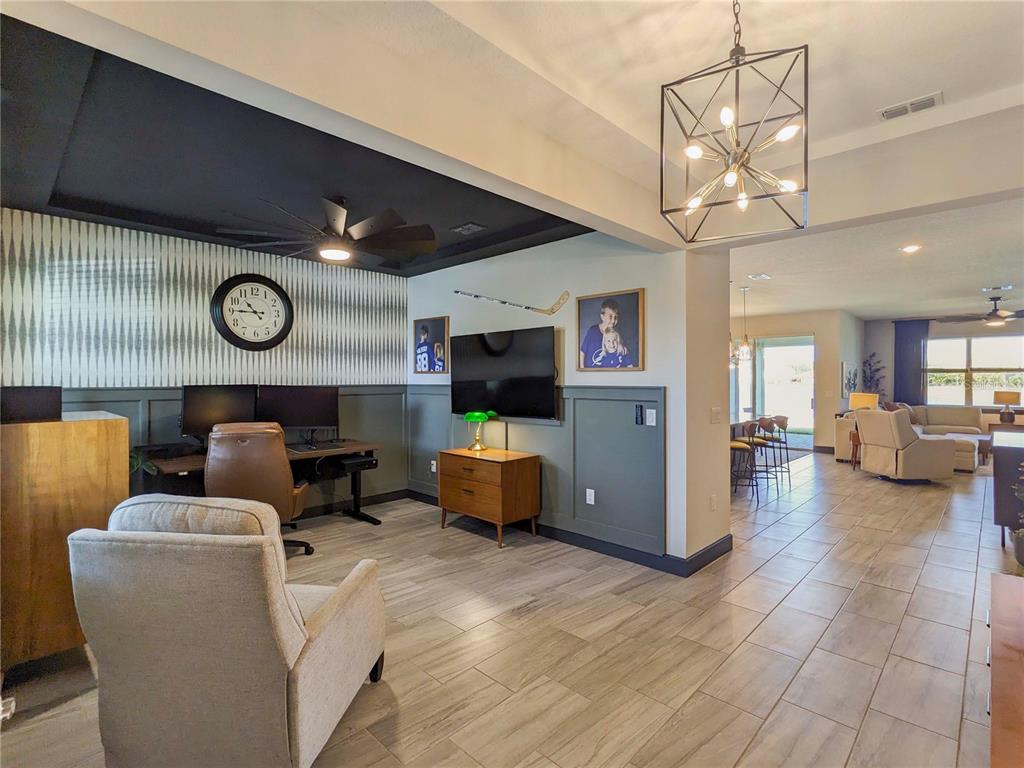 A home office area features a desk, a wall-mounted television, and a patterned accent wall — 3324 BIG SKY WAY, LAKEWOOD RANCH, FL