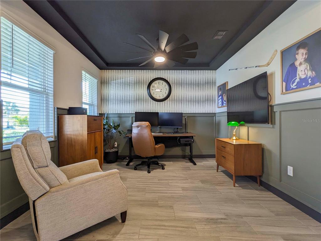 A home office features a dark ceiling, patterned wallpaper, wainscoting, and a wood desk — 3324 BIG SKY WAY, LAKEWOOD RANCH, FL