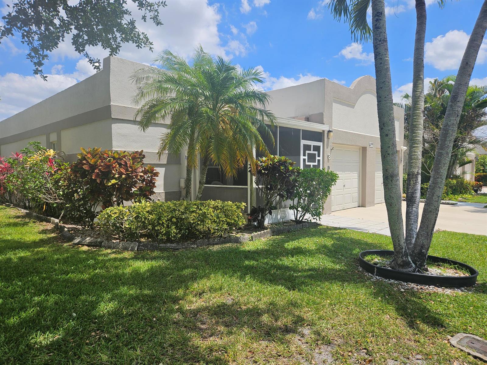 A single-story stucco home features a screened-in porch, a two-car garage, and landscaped front yard — 18999 Stewart Circle # 8, Boca Raton FL 33496, BOCA RATON, FL