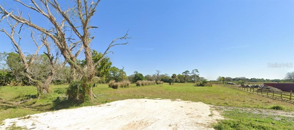 A large, grassy, undeveloped lot features a prominent dead tree and a wooden fence — 1376 NE 48TH AVENUE, OKEECHOBEE, FL