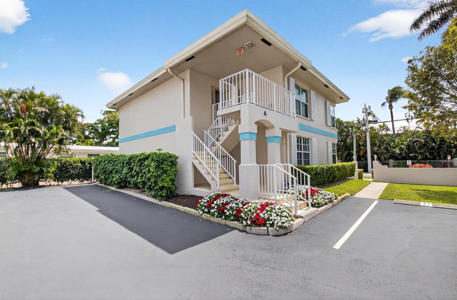 A two-story apartment building features an exterior staircase, a balcony, and a paved parking lot — 75 Venetian Drive # 2, Delray Beach FL 33483, DELRAY BEACH, FL