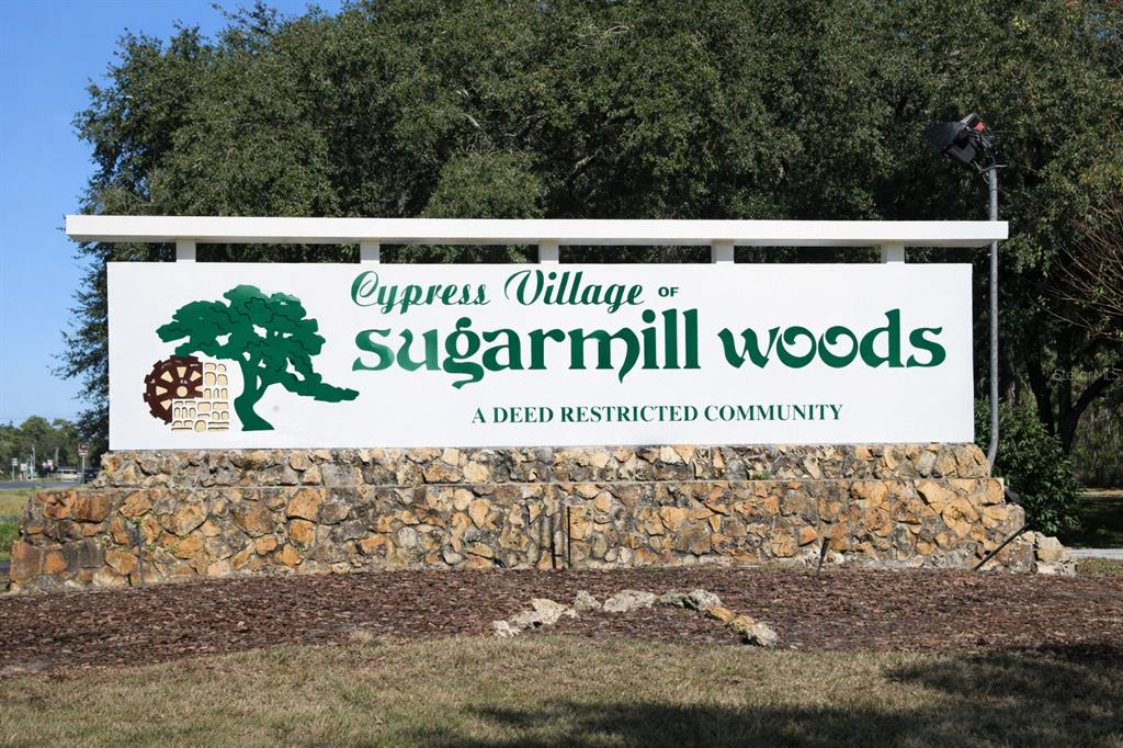 A stone-based sign for the Cypress Village of Sugarmill Woods community stands outdoors — 17 SPECEBERRY CIRCLE, HOMOSASSA, FL