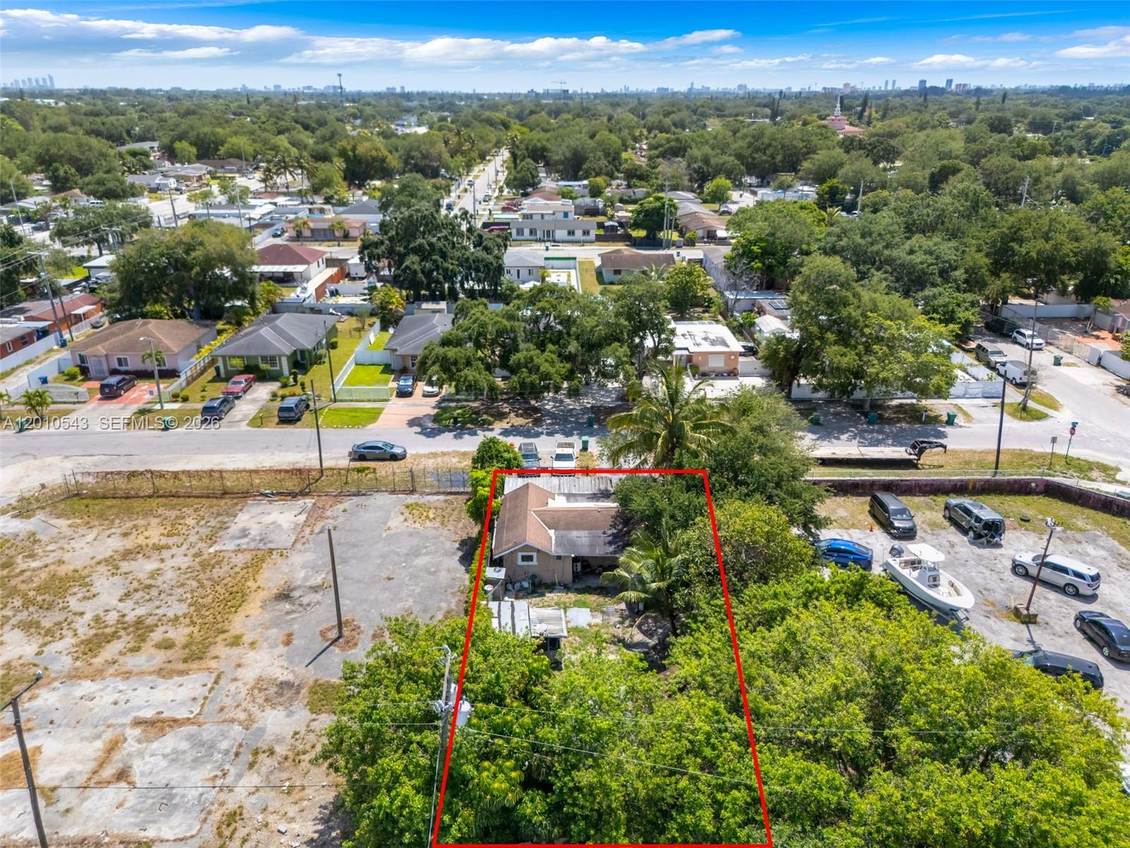 An aerial view shows a single-story house outlined in red surrounded by trees and lots — 9422 NW 26th Ave, Miami FL 33147, MIAMI, FL