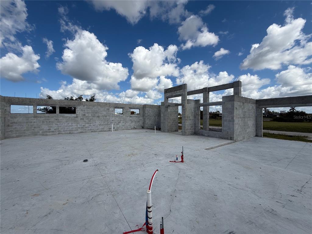 An unfinished concrete block house structure stands on a concrete slab under a blue sky — 324 NW 31ST PLACE, CAPE CORAL, FL