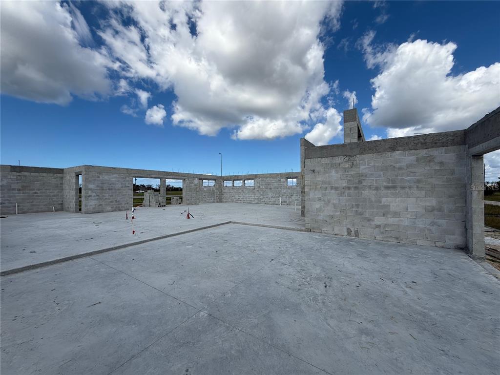 An unfinished concrete block structure with a poured concrete floor under a blue sky — 324 NW 31ST PLACE, CAPE CORAL, FL
