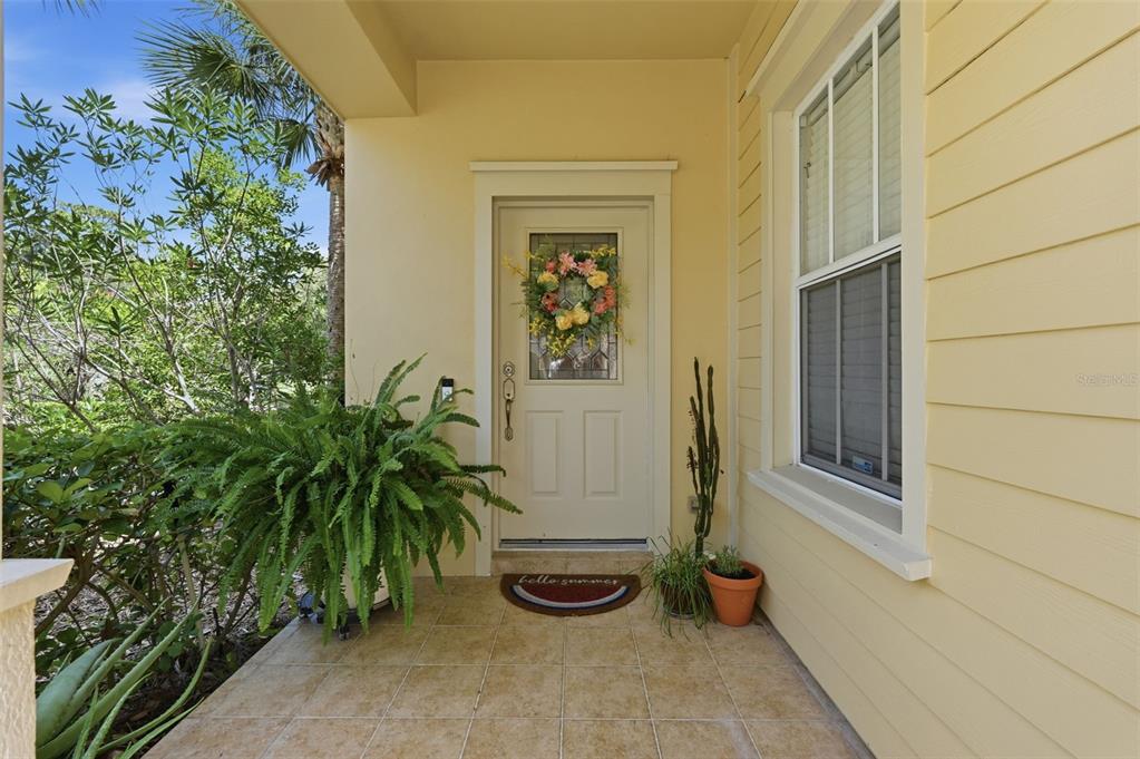A covered front porch with a light-colored door, a fern, and a welcome mat — 2656 TANGLEWOOD TRAIL, PALM HARBOR, FL