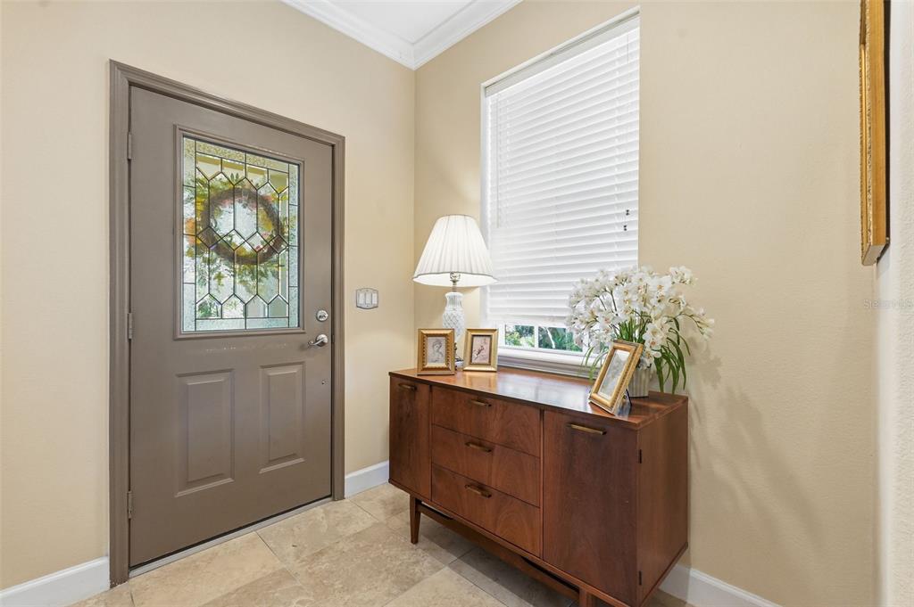 An entryway features a brown door with a decorative glass insert and a wooden sideboard — 2656 TANGLEWOOD TRAIL, PALM HARBOR, FL