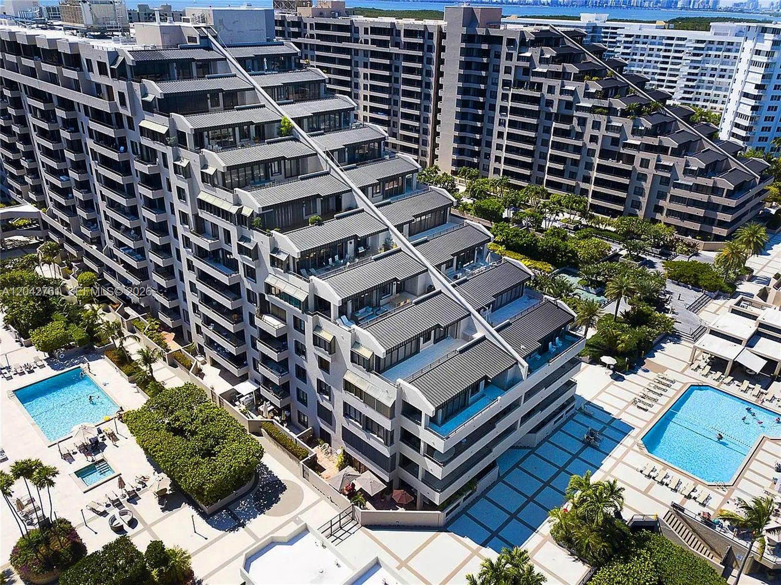 An aerial view of a tiered apartment complex featuring two swimming pools and landscaped grounds — 201 Crandon Blvd # 643, Key Biscayne FL 33149, KEY BISCAYNE, FL