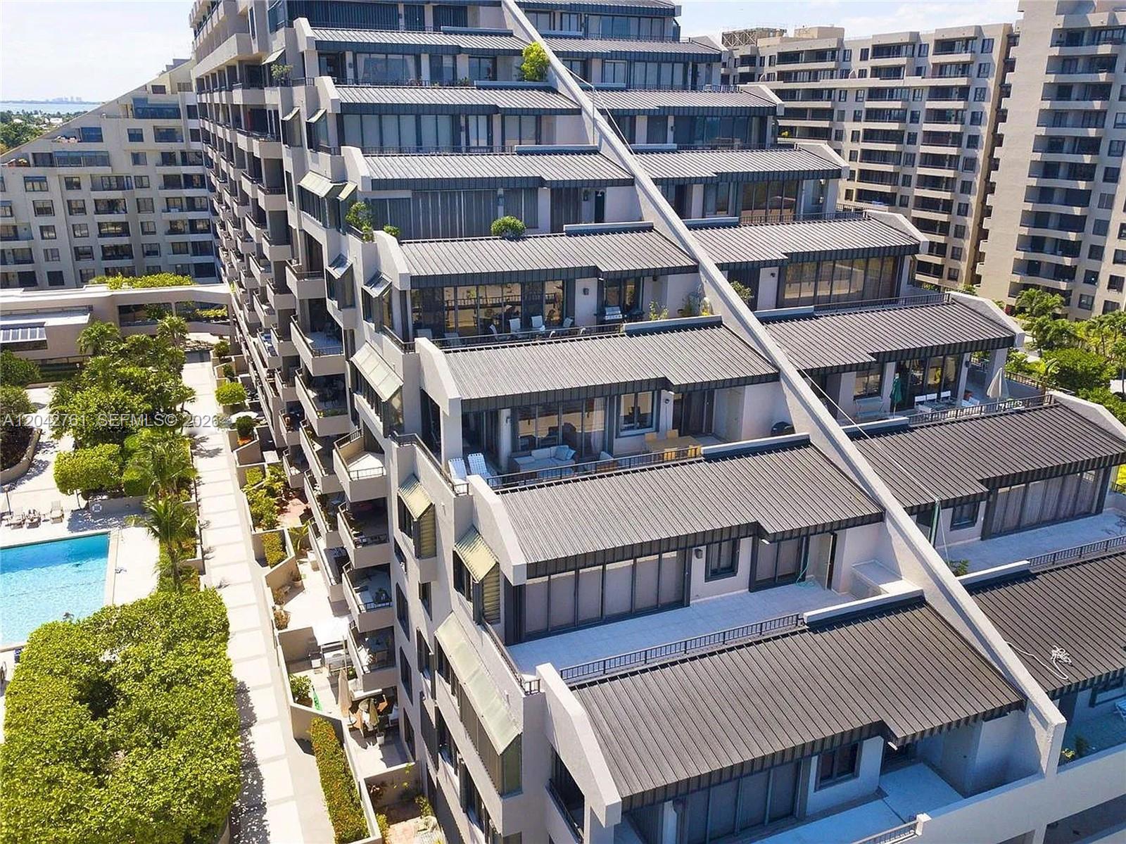An aerial view shows the stepped exterior terraces and metal roofs of a modern apartment building — 201 Crandon Blvd # 643, Key Biscayne FL 33149, KEY BISCAYNE, FL