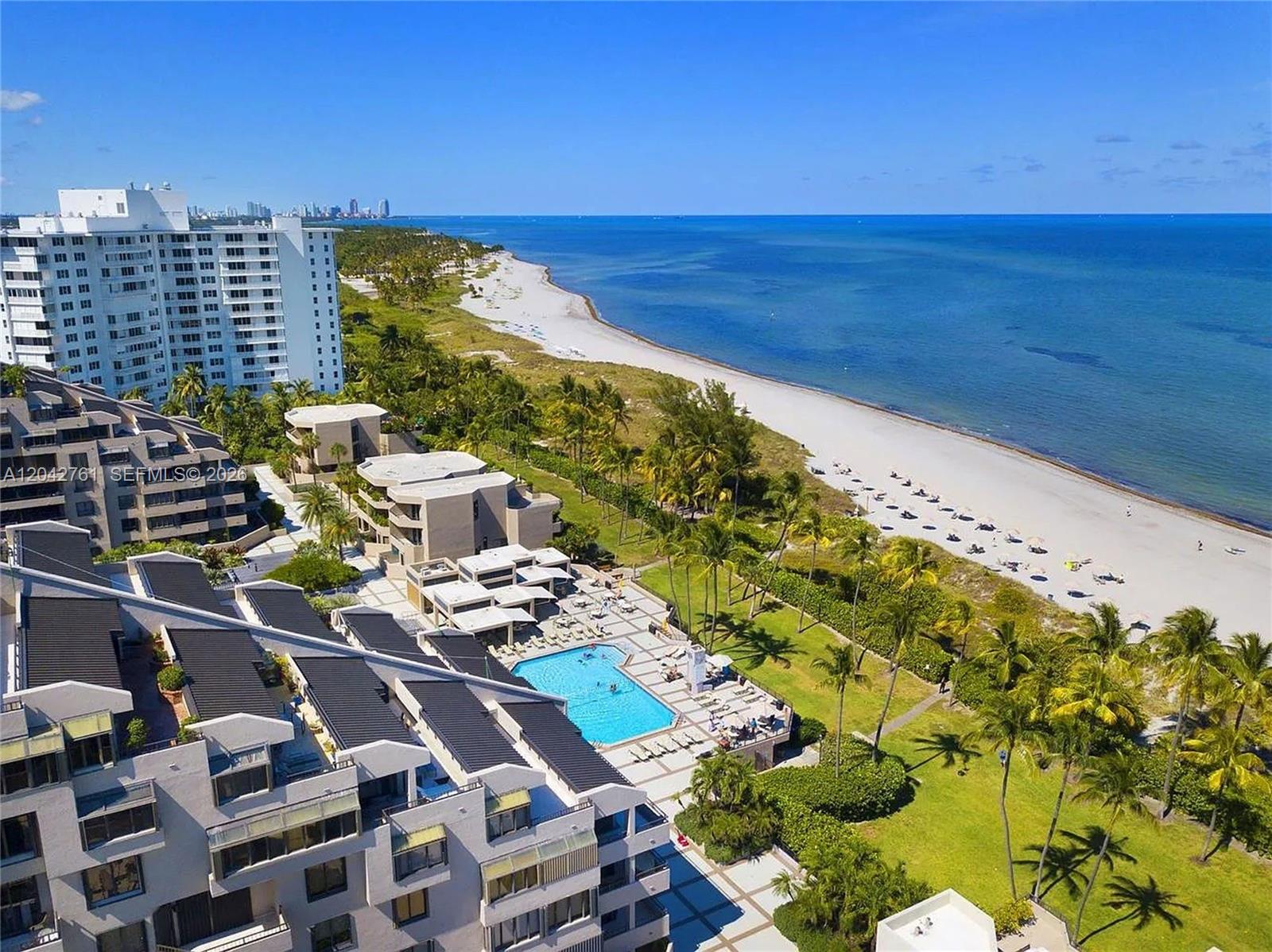 An aerial view shows a beachfront condominium complex with a swimming pool and palm trees — 201 Crandon Blvd # 643, Key Biscayne FL 33149, KEY BISCAYNE, FL