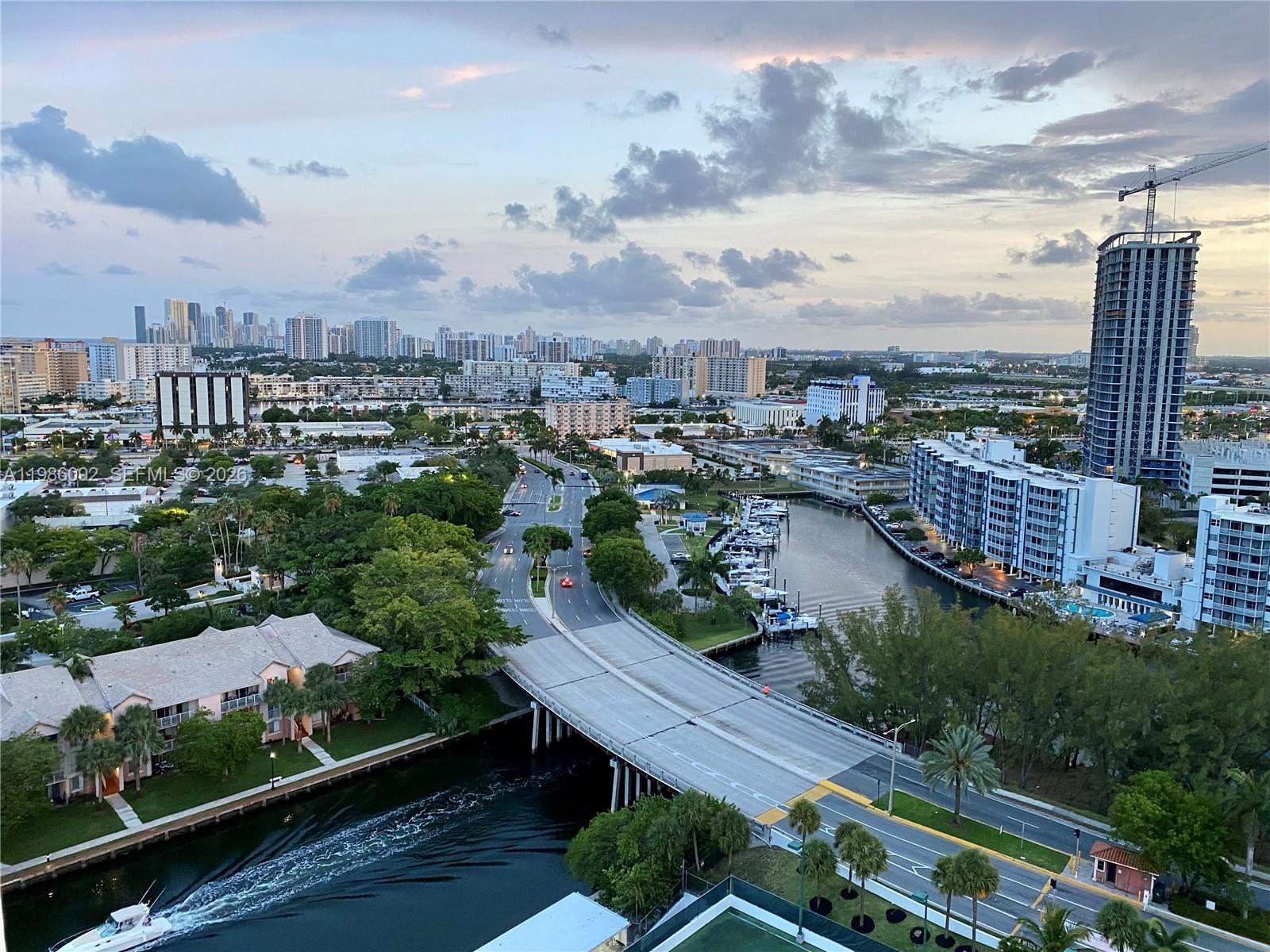 An elevated view shows a bridge over a canal, surrounding buildings, and a distant skyline — 300 Three Islands Blvd # 520, Hallandale Beach FL 33009, HALLANDALE BEACH, FL