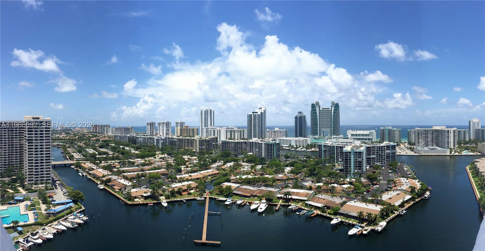 An elevated view of a coastal city featuring residential buildings, canals, and docked boats — 300 Three Islands Blvd # 520, Hallandale Beach FL 33009, HALLANDALE BEACH, FL