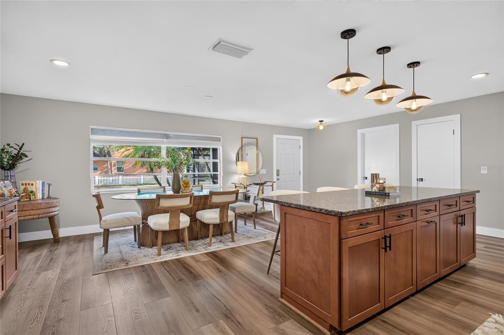 A kitchen with a wooden island and a dining area featuring a glass-topped table — 7312 S FITZGERALD STREET, TAMPA, FL