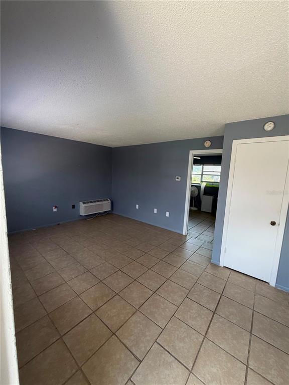 A room with gray walls, beige tile flooring, and a white door — 223 ORANGE STREET UNIT 1-6, AUBURNDALE, FL
