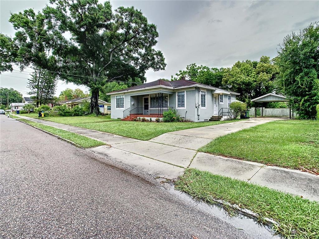 A single-story gray house with a front porch, concrete driveway, and a detached carport — 2211 DURHAM STREET, TAMPA, FL