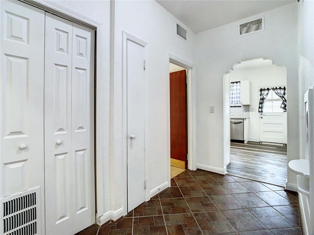 A hallway with tile flooring leads to a kitchen through an arched doorway — 2211 DURHAM STREET, TAMPA, FL
