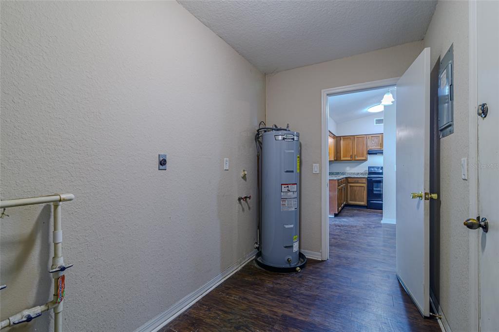A utility room features a water heater, laundry hookups, and a doorway leading to a kitchen — 6362 NW 64TH TERRACE, OCALA, FL
