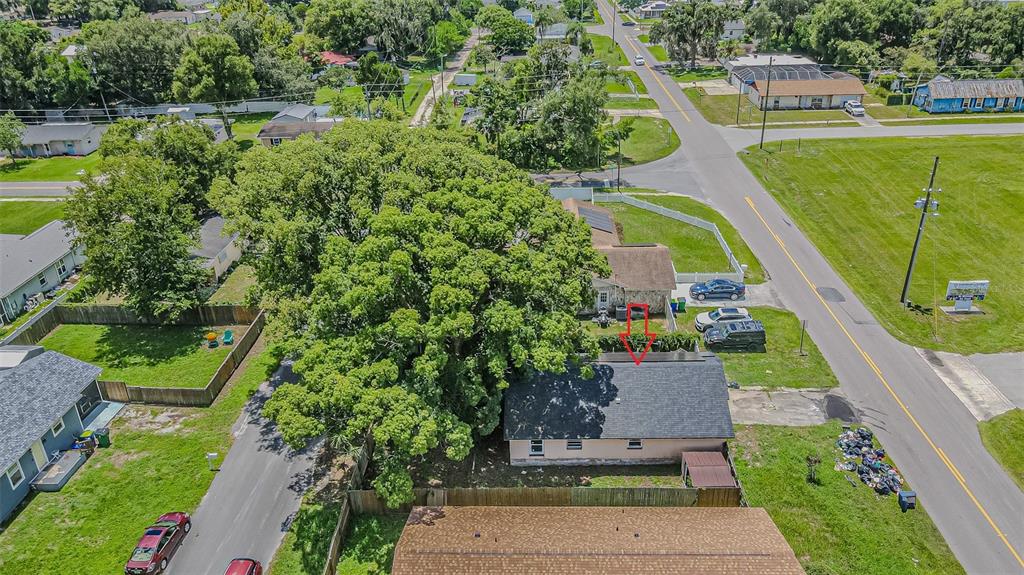 An aerial view shows a house with a large tree and a red arrow pointing down — 5512 20TH STREET, ZEPHYRHILLS, FL
