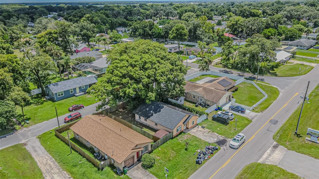 An aerial view shows several single-story houses with fenced yards and large trees on streets — 5512 20TH STREET, ZEPHYRHILLS, FL
