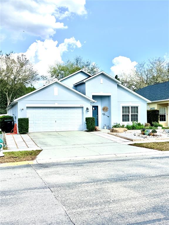 A light blue single-story house features a two-car garage and a paved driveway — 4339 NORTHERN DANCER WAY, ORLANDO, FL