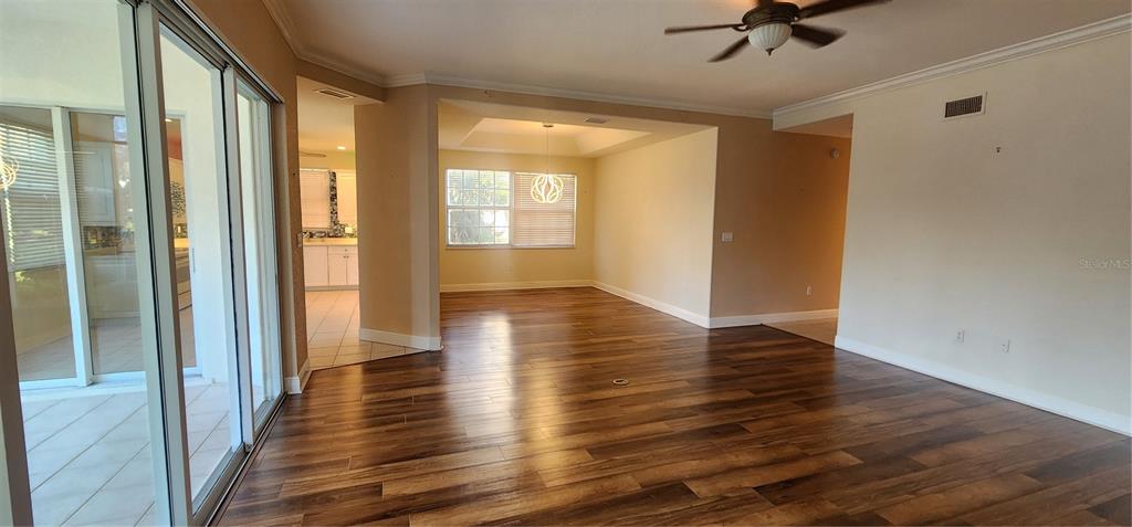 An open-concept living area features wood-look flooring, a ceiling fan, and a separate dining space — 197 TROPICANA DRIVE UNIT 1512, PUNTA GORDA, FL