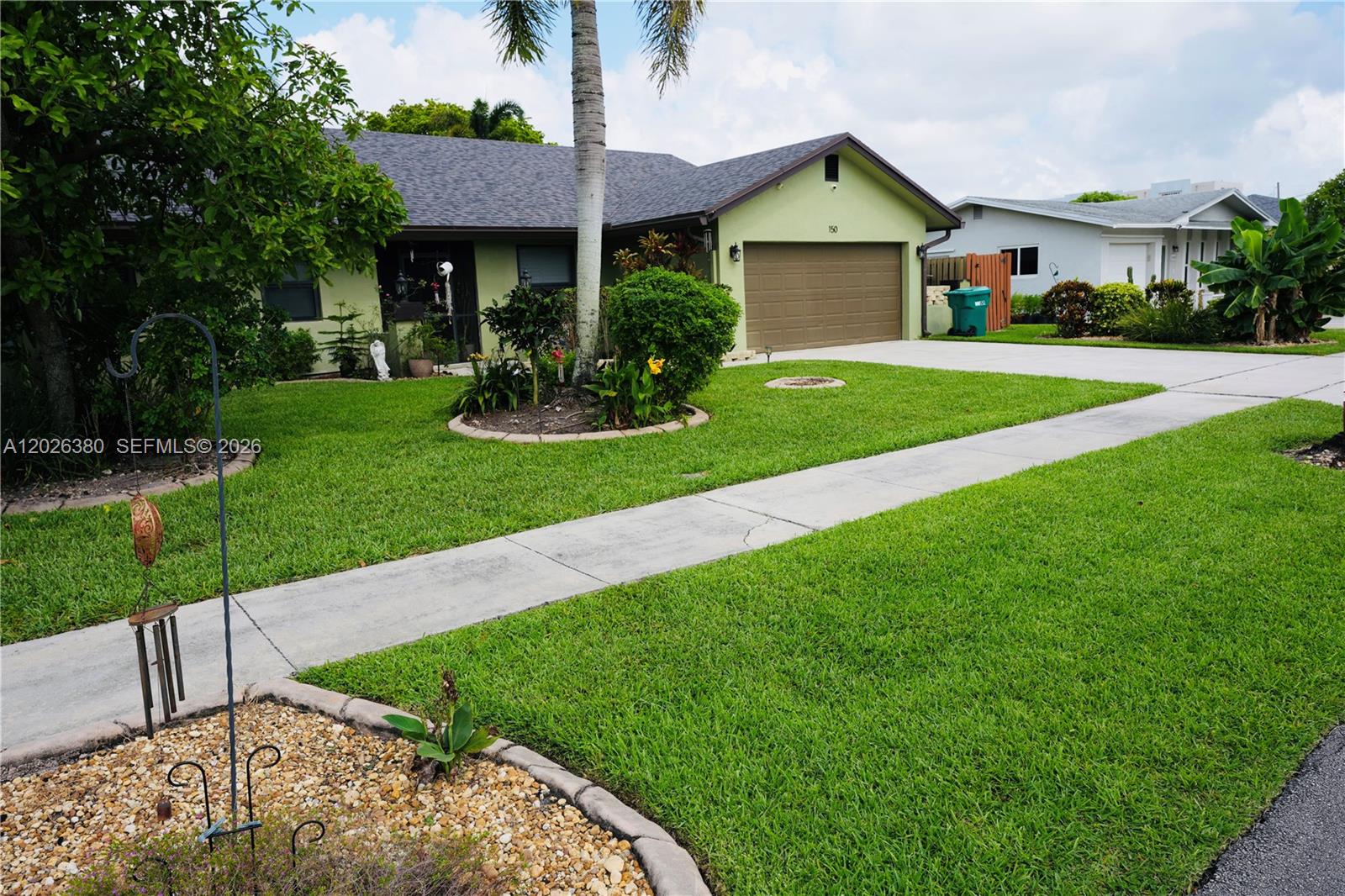A light green single-story house features a brown garage door and a landscaped front yard — 150 SW 127th Ave, Plantation FL 33325, PLANTATION, FL