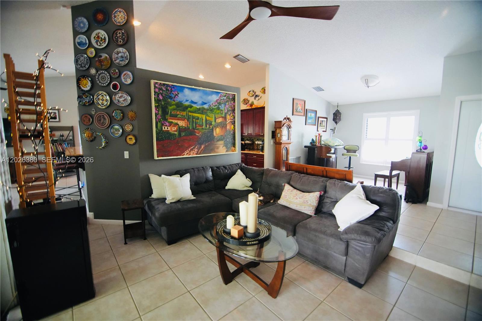 A living room features a dark gray sectional sofa, a glass coffee table, and wall-mounted plates — 150 SW 127th Ave, Plantation FL 33325, PLANTATION, FL