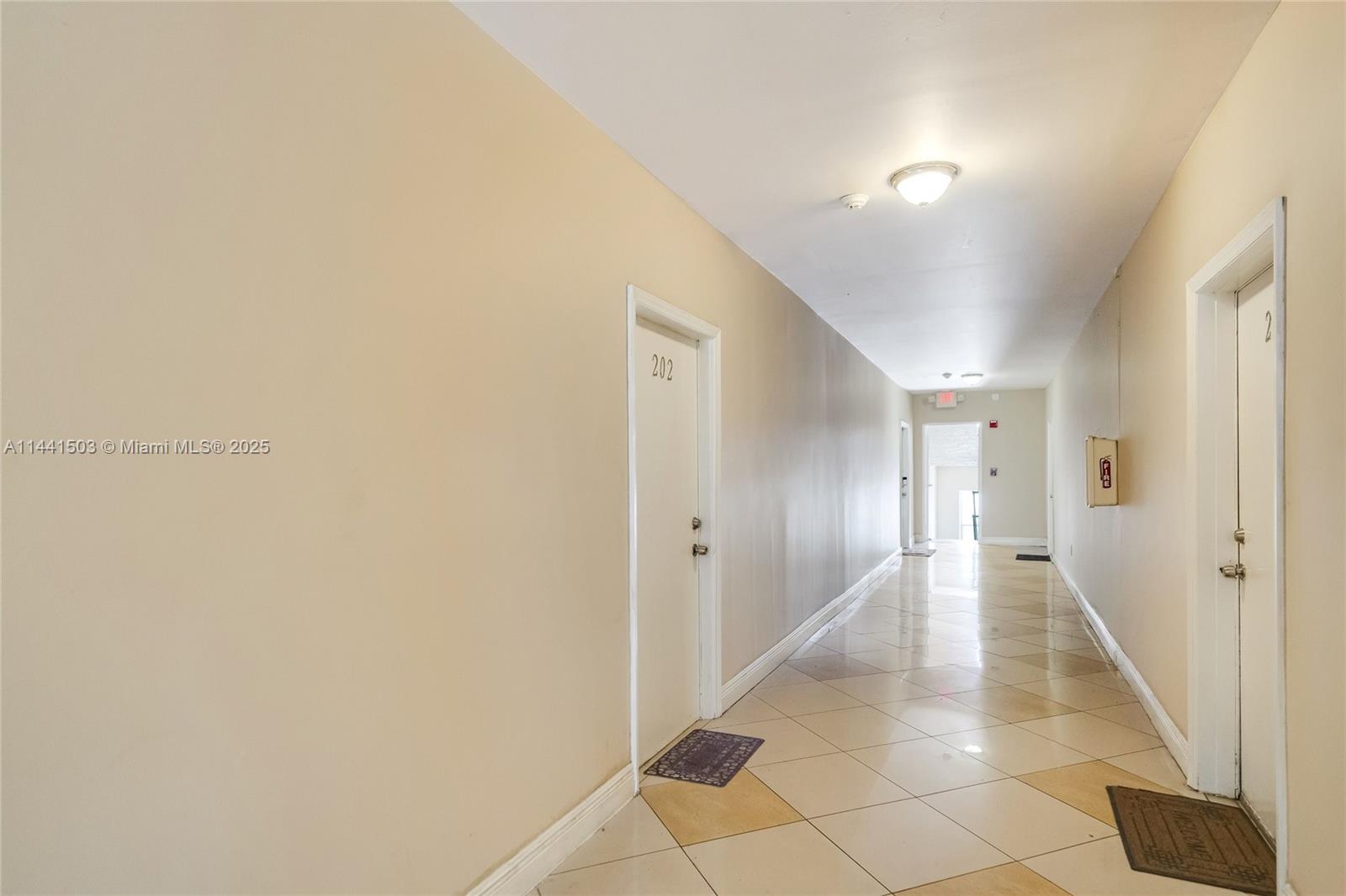 A hallway with beige walls, tiled floors, and two doors labeled 202 and 2 — 440 SW 5th Ave, Miami FL 33130, MIAMI, FL