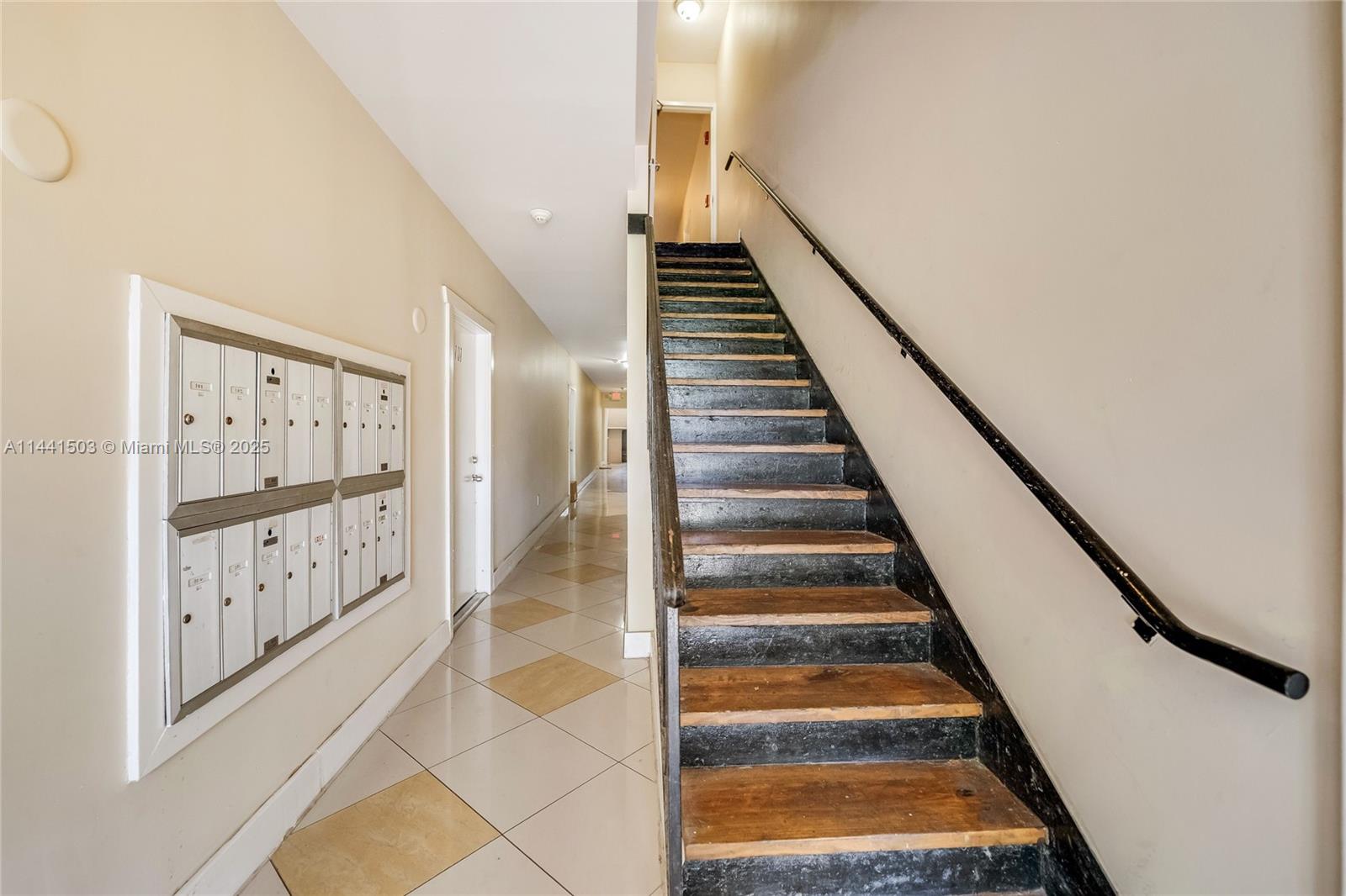 An indoor hallway features a staircase with dark wooden steps and a wall-mounted mailbox unit — 440 SW 5th Ave, Miami FL 33130, MIAMI, FL