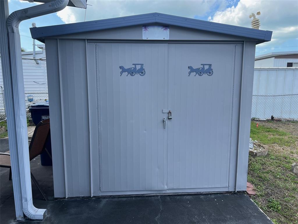 A gray metal storage shed with double doors stands on a concrete pad outdoors — 6580 SEMINOLE BOULEVARD UNIT 300, SEMINOLE, FL